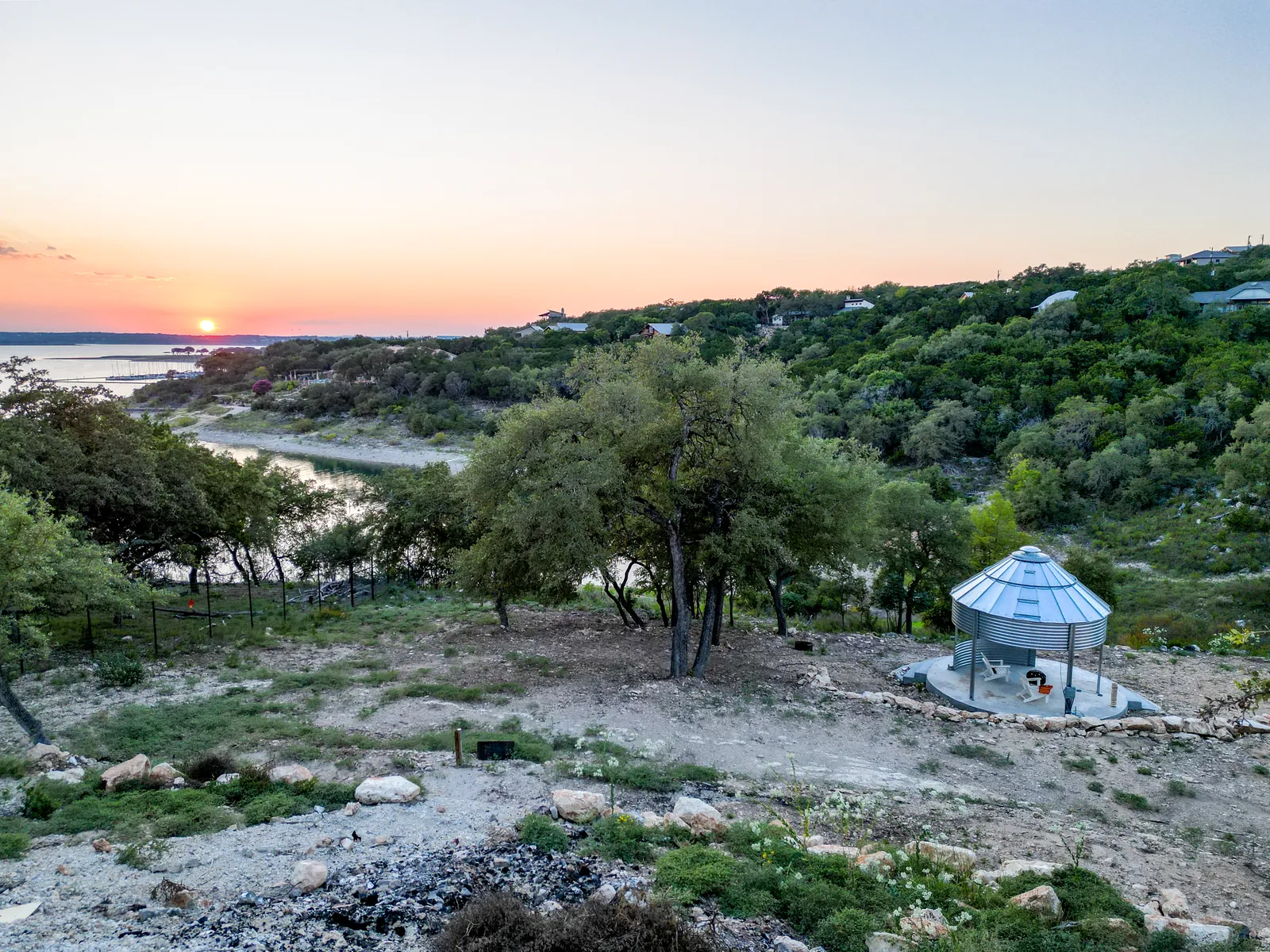Sunset over Canyon Lake with a metal gazebo on the grounds of The Container Retreat in the Texas Hill Country