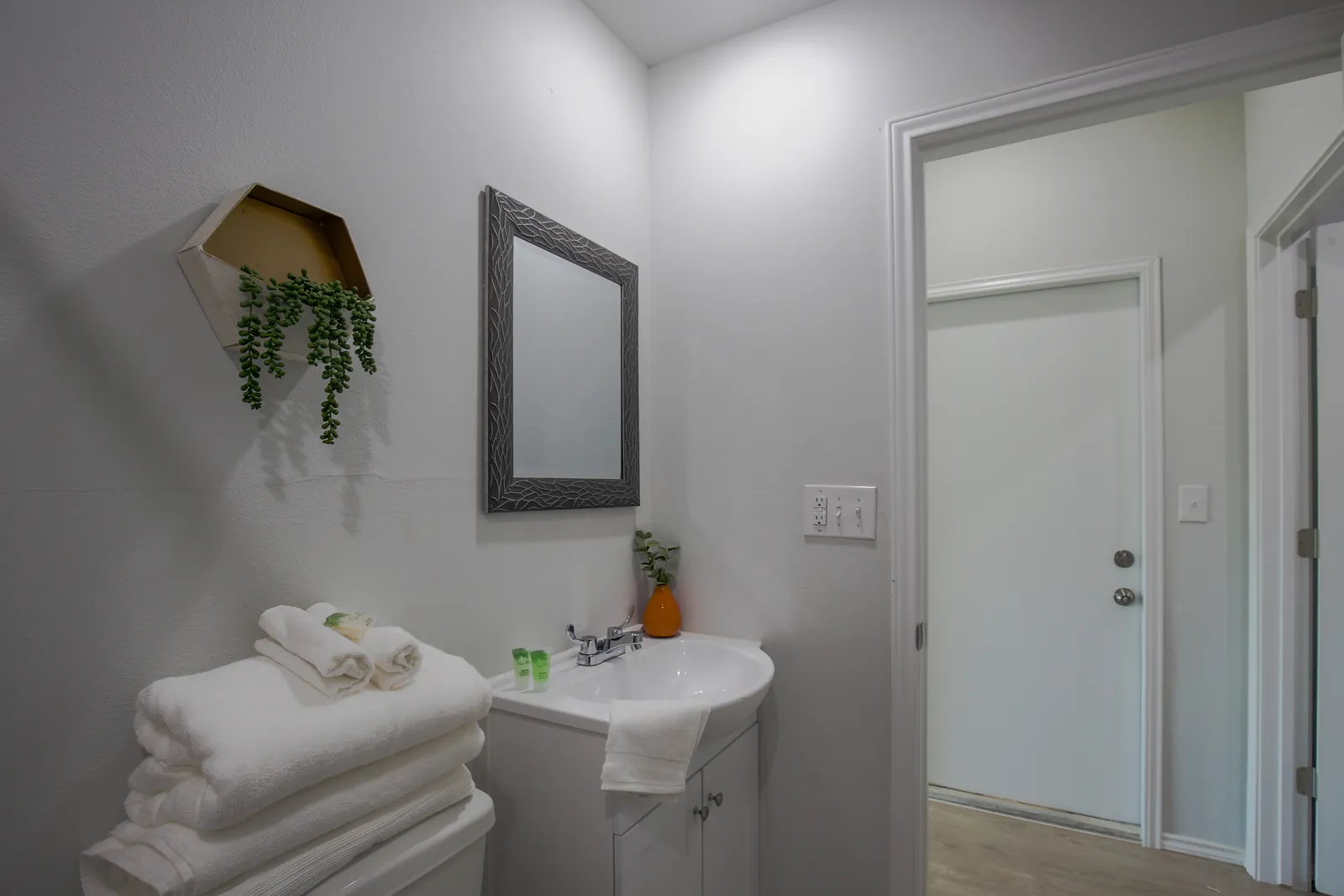 Furnished bathroom with vanity, mirror, and fresh towels in a container home