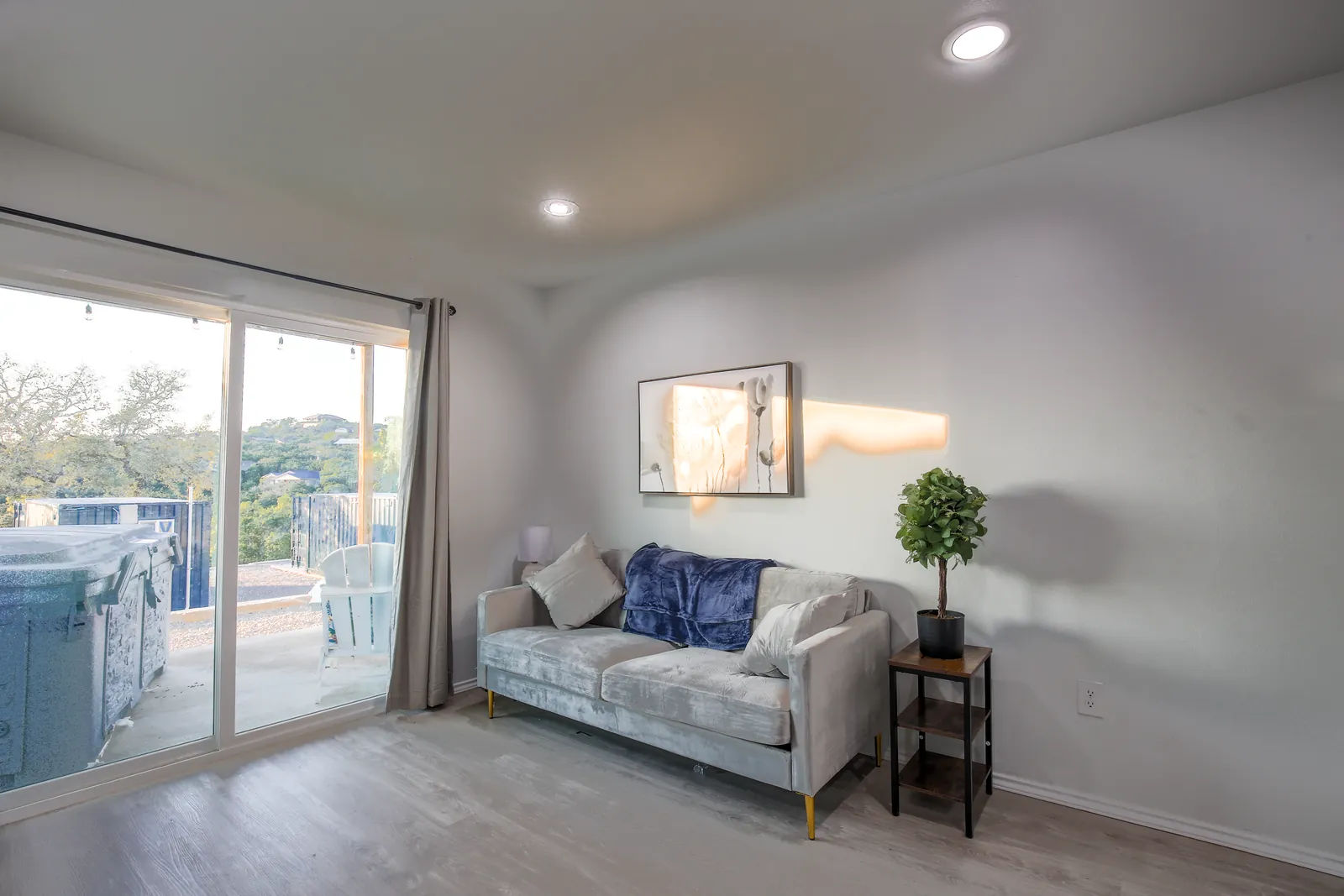 Furnished living room with a sliding door opening to a private deck with a hot tub at The Container Retreat
